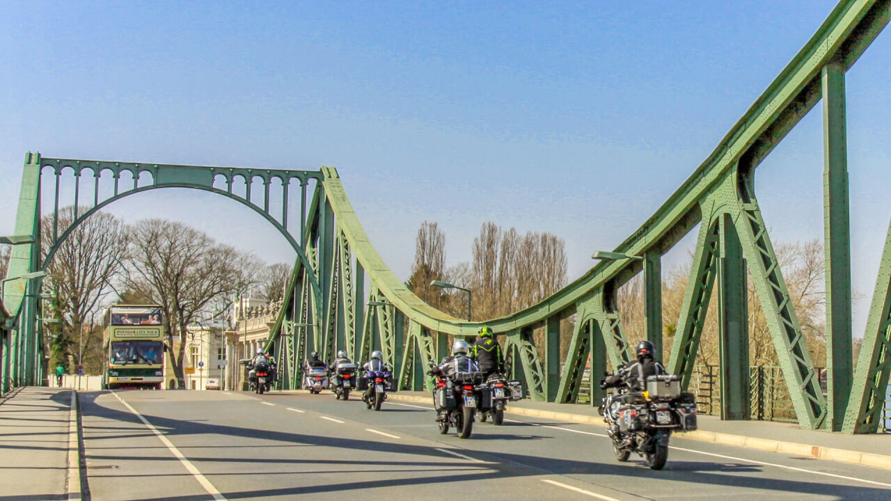 Motorradgruppe fährt über eine grüne Stahlbrücke Motorradgruppe fährt über eine grüne Stahlbrücke