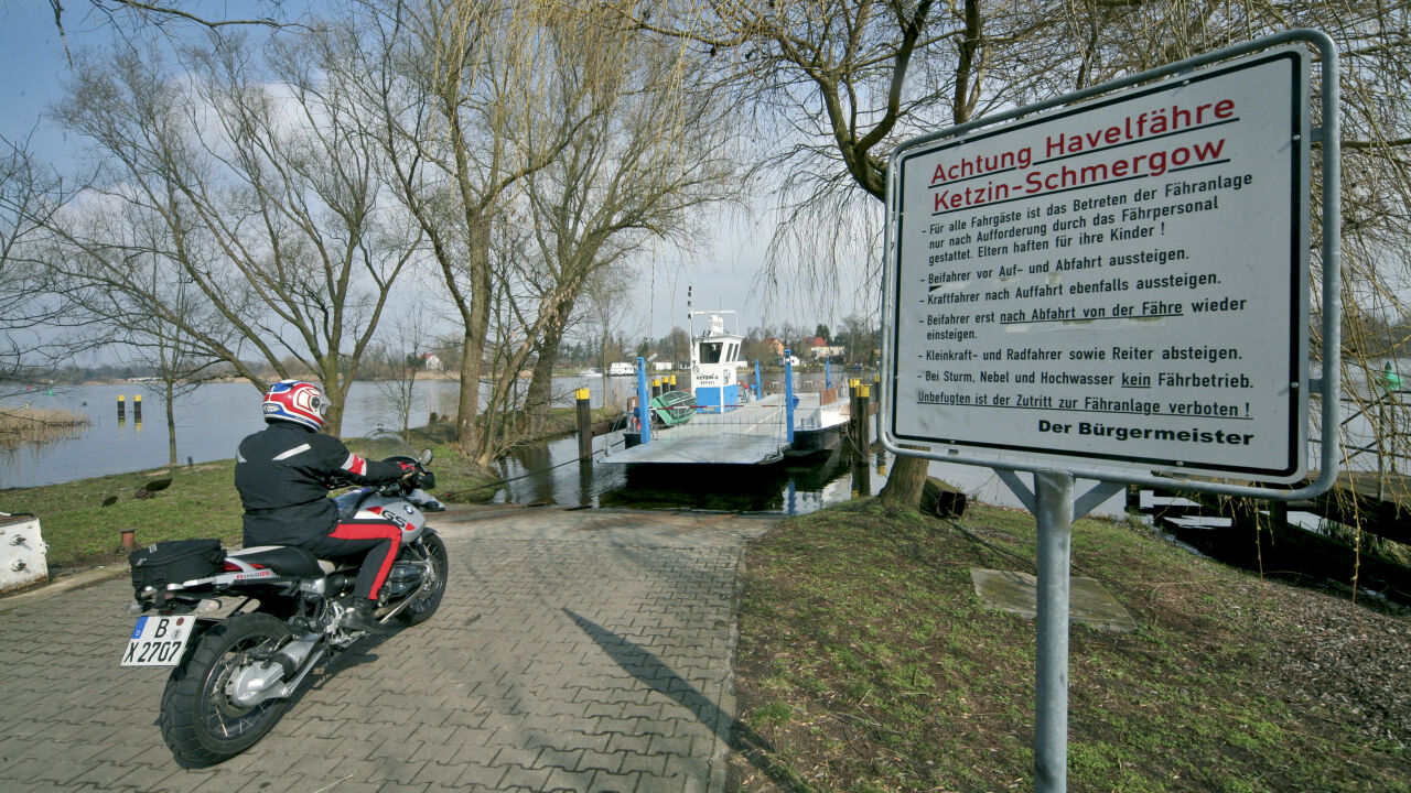 Motorrad an einer Anlegestelle, daneben ein Schild der Havelfähre Ketzin–Schmergow Motorrad an einer Anlegestelle, daneben ein Schild der Havelfähre Ketzin–Schmergow